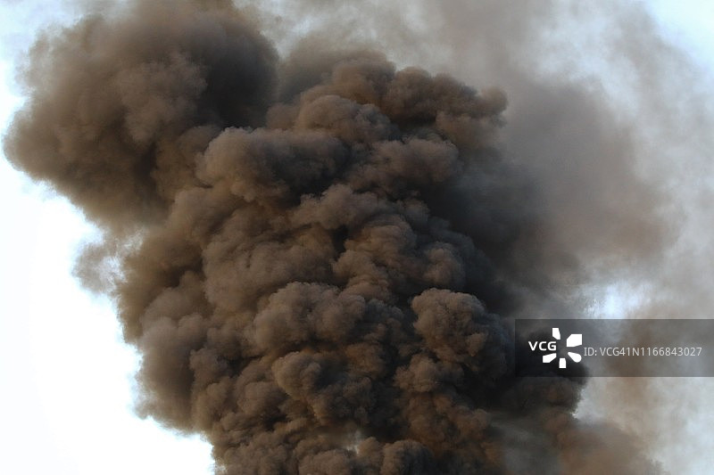 晴朗天空中浓厚的黑烟图片素材
