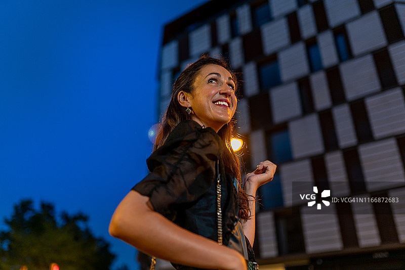 夜晚在格拉西亚大道上行走的优雅女人图片素材