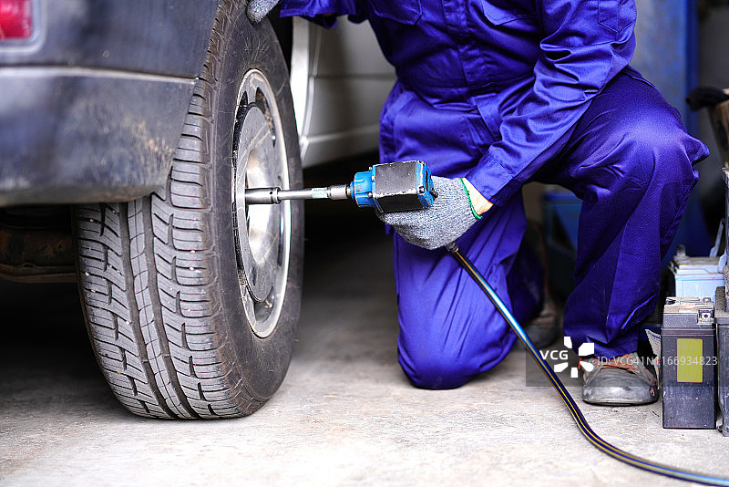 技工使用冲击扳手更换轮胎图片素材