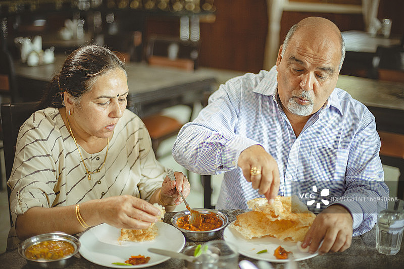 快乐的老年夫妇在餐厅共进午餐图片素材