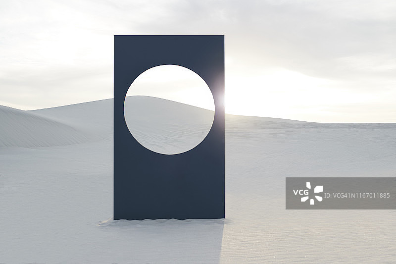 日落时白色沙漠上的圆形窗框标语牌图片素材