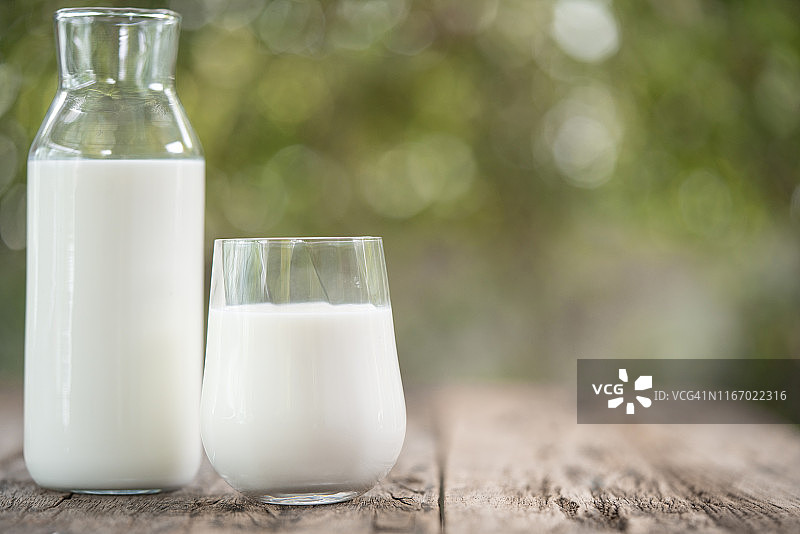 木桌上的牛奶瓶和牛奶杯图片素材