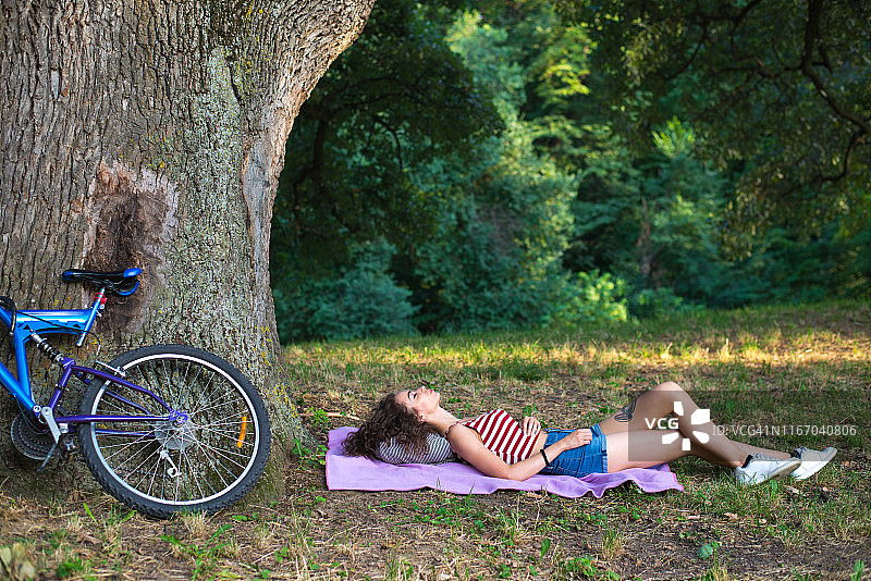 年轻女人在户外骑自行车后休息图片素材