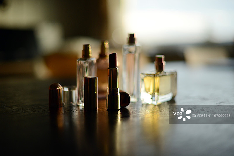 四瓶香水和红色口红在阳光下图片素材