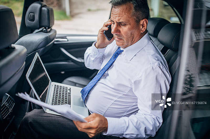 坐在汽车后座的商人图片素材