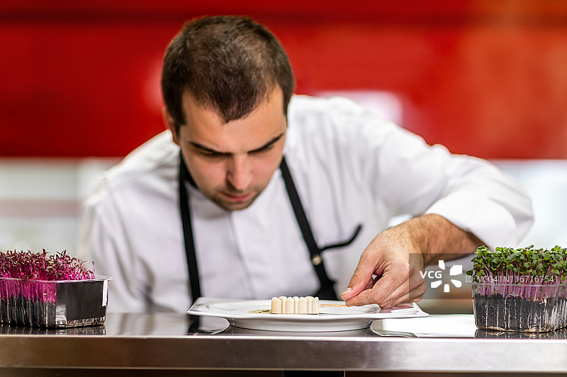 厨师在餐厅厨房的分子美食小菜中放入小冰淇淋棒图片素材