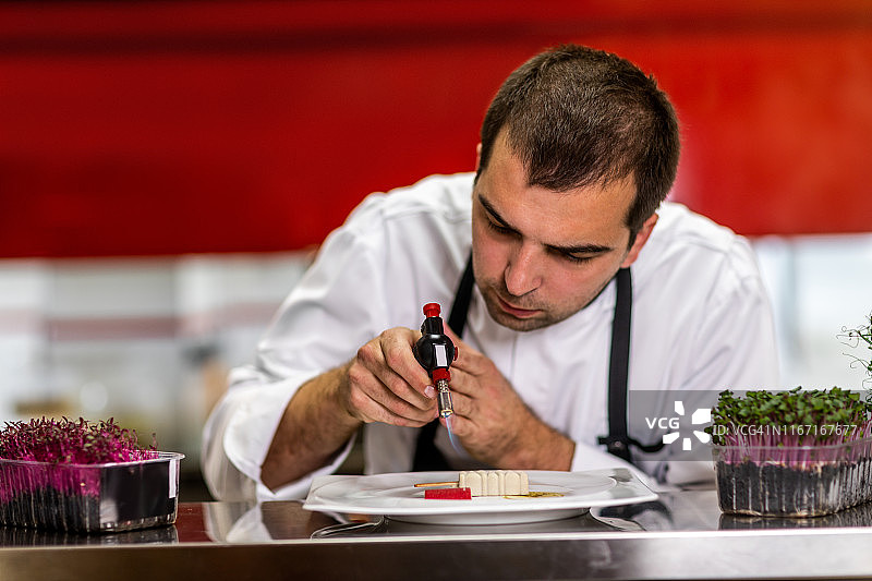 厨师使用喷枪为分子料理上釉图片素材