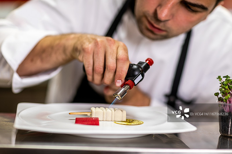 厨师在餐厅厨房用喷枪为分子料理焦糖化图片素材