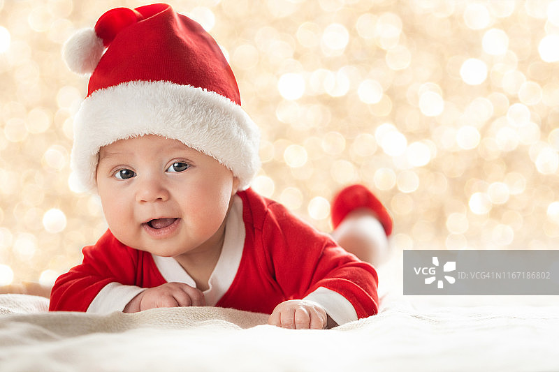 圣诞主题：身穿圣诞老人服装和戴圣诞帽的婴儿图片素材