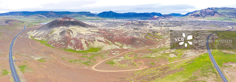 航拍冰岛伪火山口附近的美丽公路，山脉背景图片素材