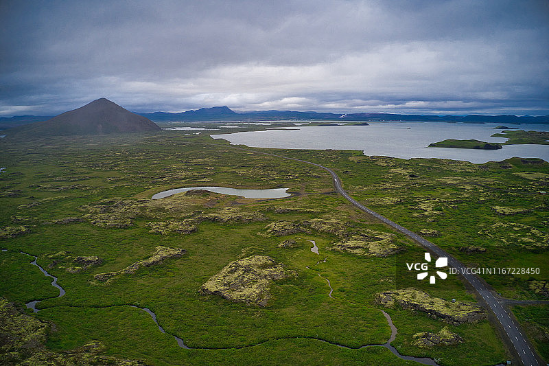 冰岛熔岩地貌上美丽的冰岛公路鸟瞰图，覆盖着苔藓，背景是山脉图片素材