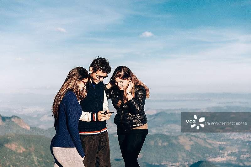 朋友们在户外使用智能手机图片素材