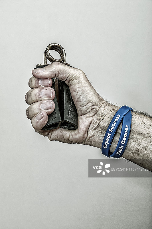 癌症幸存的老年男人正在挤压手部握力器图片素材