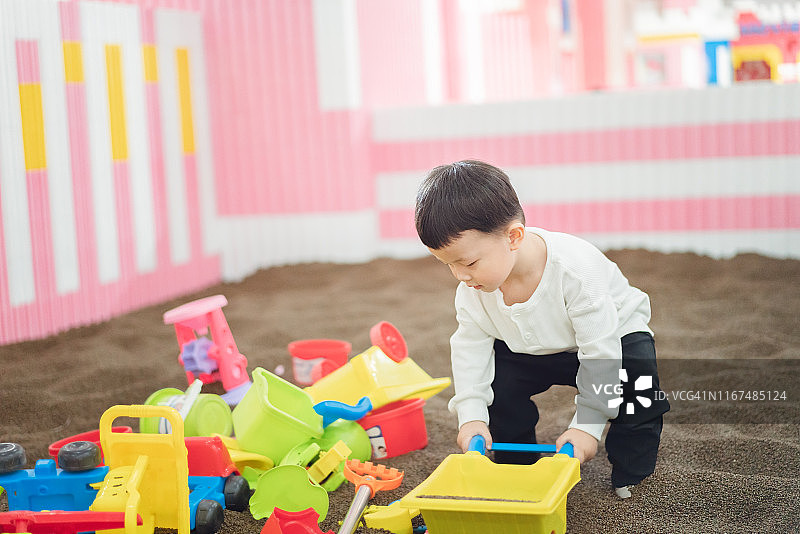 可爱的小男孩玩沙子图片素材
