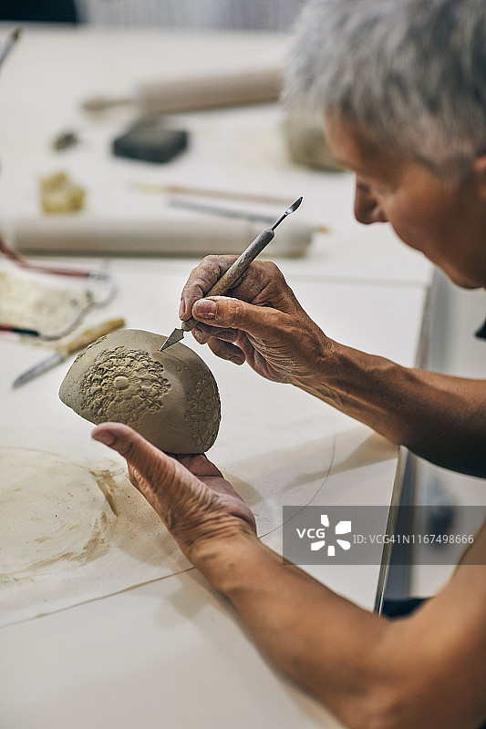 在陶瓷工作室享受乐趣的老年妇女图片素材