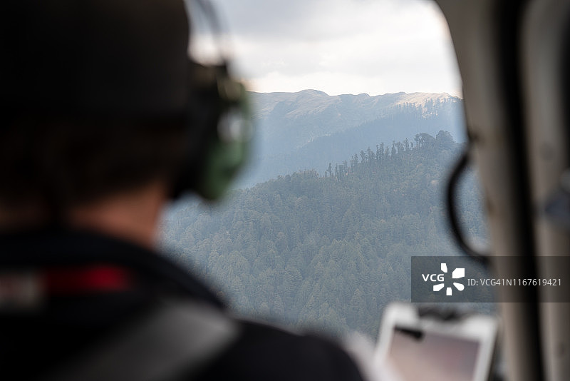 直升机飞行员飞越山顶图片素材