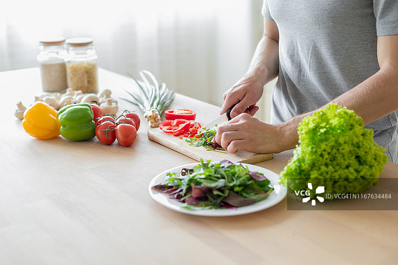 男人准备健康的蔬菜沙拉图片素材