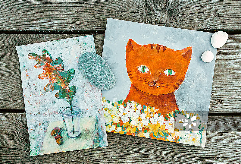 木制背景上的两幅插图：石头、木头和姜猫与白花的平铺构图图片素材