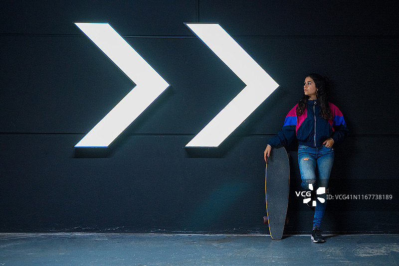 穿着休闲装的年轻女孩拿着长板图片素材