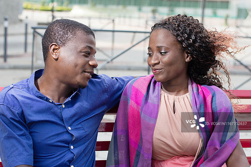 这些年轻人面对面坐着，面带微笑地看着彼此的眼睛图片素材