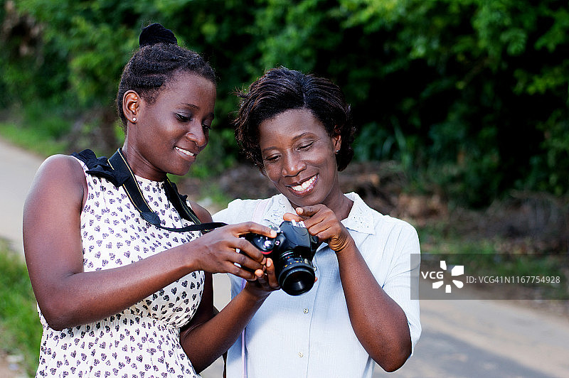 年轻摄影师向女友展示她拍摄的美丽照片图片素材