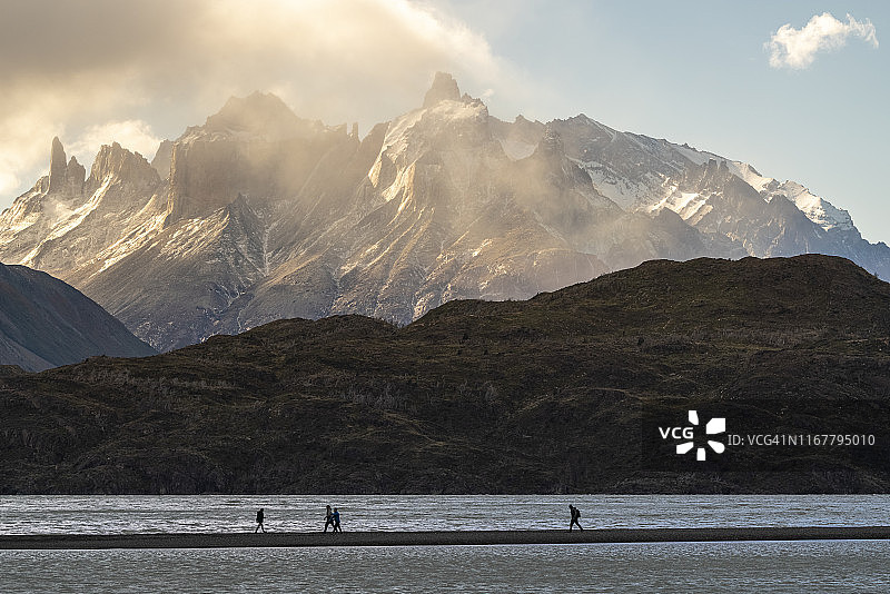 在智利百内国家公园灰色湖岸边行走的人们图片素材
