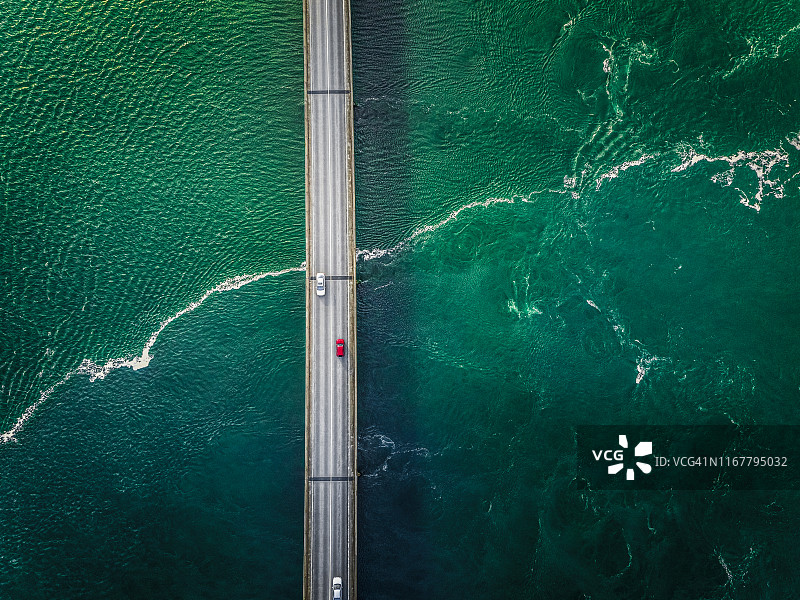 汽车行驶在桥上，桥下是绿色的水流图片素材