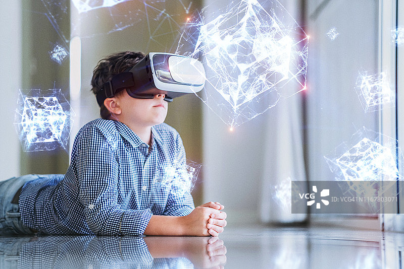 戴着VR眼镜学习几何形状全息图的男孩图片素材