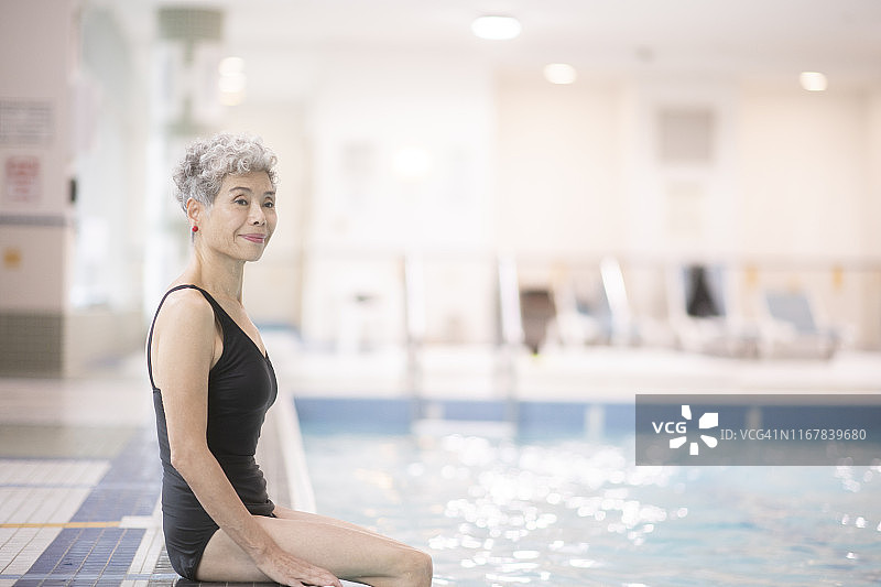 坐在游泳池边的年长女性图片素材