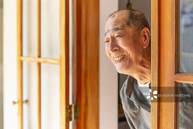 向门口外看的年长男人图片素材