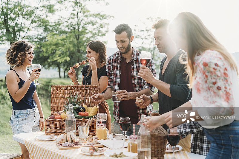 朋友们在烧烤派对上制作开胃酒和喝葡萄酒图片素材