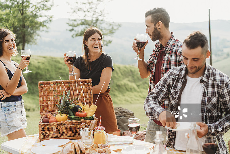 朋友们在烧烤派对上制作开胃酒和喝葡萄酒图片素材
