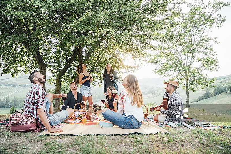 朋友们在乡村日落时一起野餐图片素材