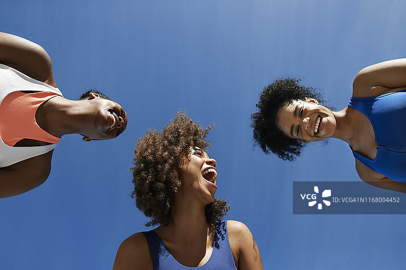 在蓝天下身穿运动服的快乐女运动员图片素材