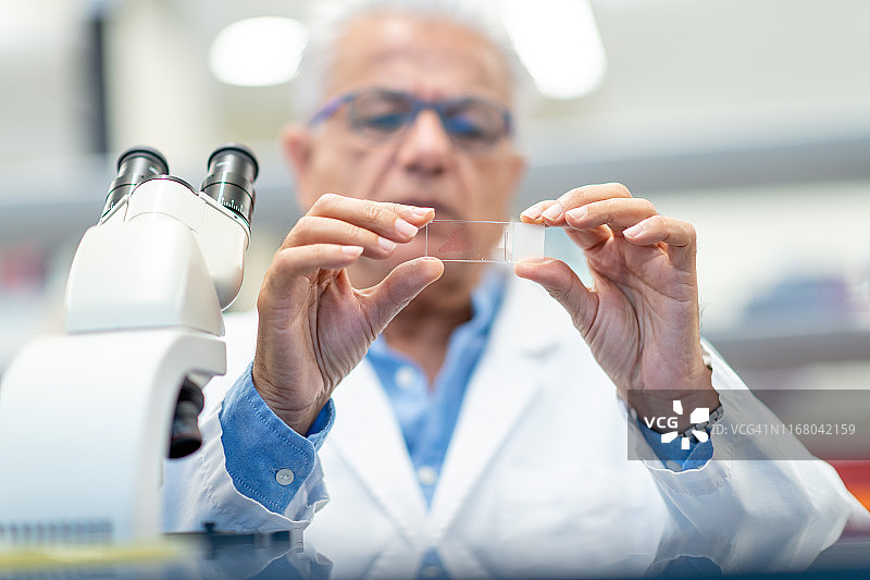 将样品放入显微镜前进行分析的男化学师图片素材