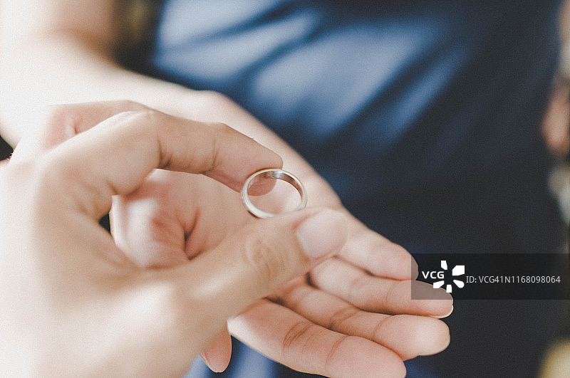 一对年轻夫妇的手拿着结婚戒指，离婚概念图片素材
