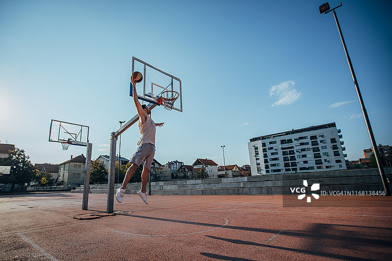 男人在街头篮球场扣篮图片素材