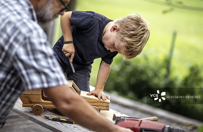 祖孙俩用木头制作汽车图片素材