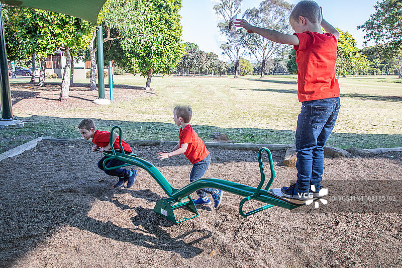 三个男孩在玩跷跷板图片素材