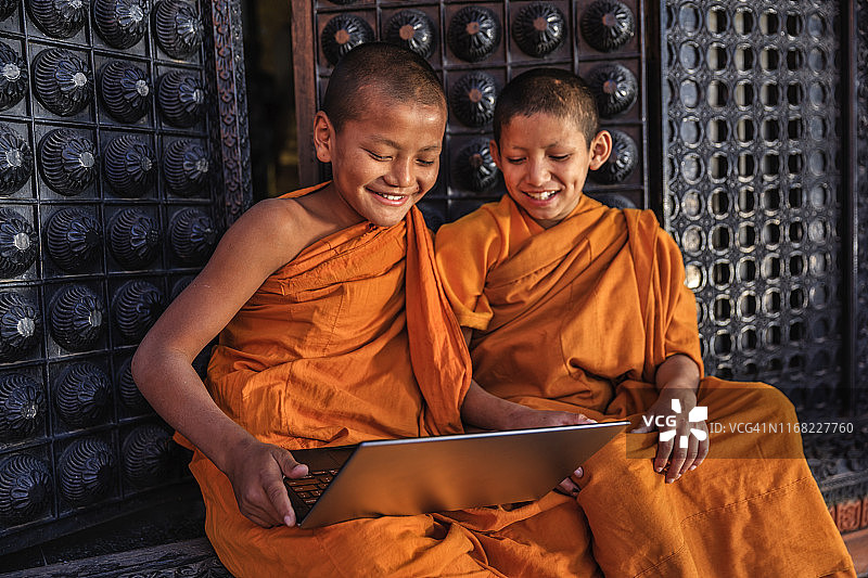 在巴克塔普尔使用笔记本电脑的佛教新手僧侣图片素材
