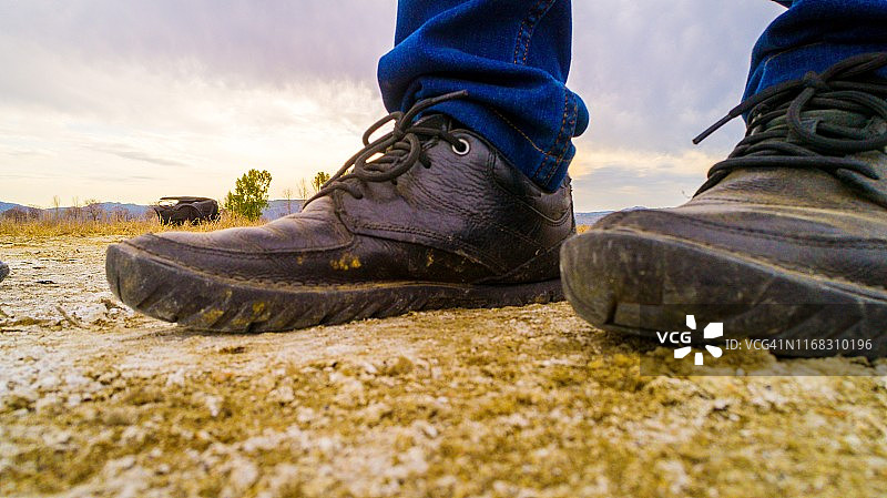 穿着登山鞋走过泥泞干燥的土地图片素材