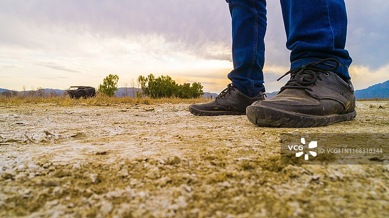 穿着登山鞋走过泥泞干燥的土地图片素材