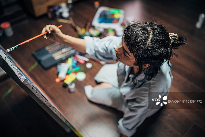 女人在家中工作室的地板上绘画图片素材