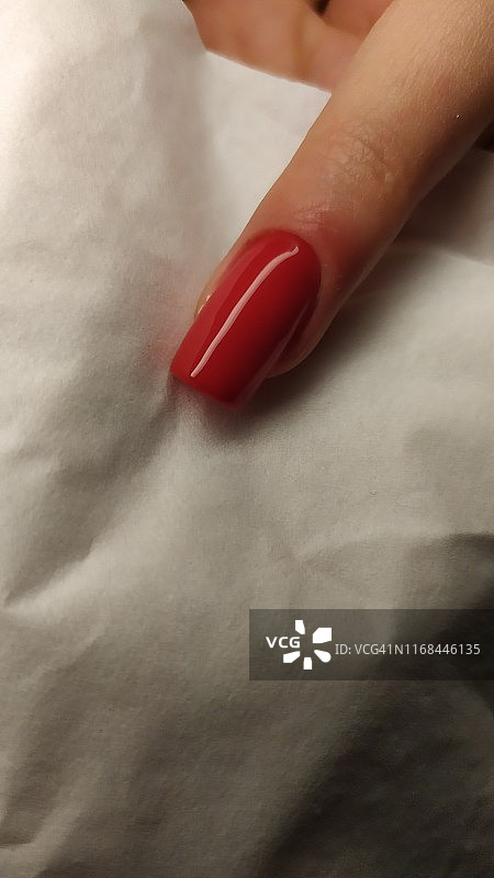 女人手指亮红色美甲特写图片素材