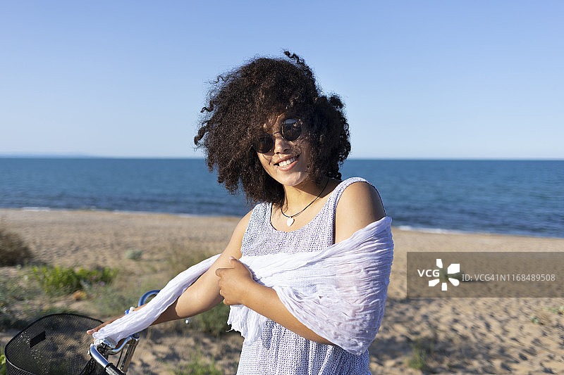 在海滩上骑自行车的快乐女人图片素材