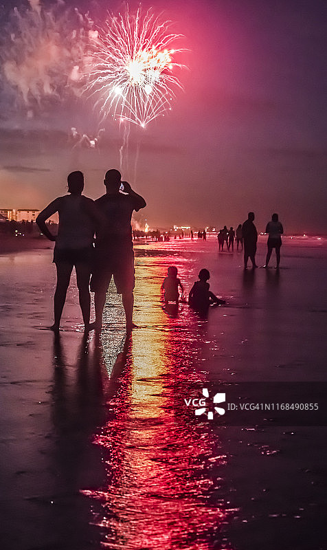 孩子们在玩耍，父母观看海滩烟花表演图片素材