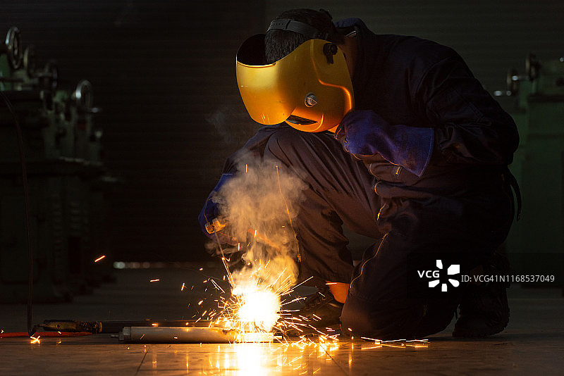 工人佩戴安全面罩和手套焊接钢材图片素材
