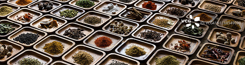 旧木背景上木托盘中多种色彩鲜艳的有机干印度香料图片素材