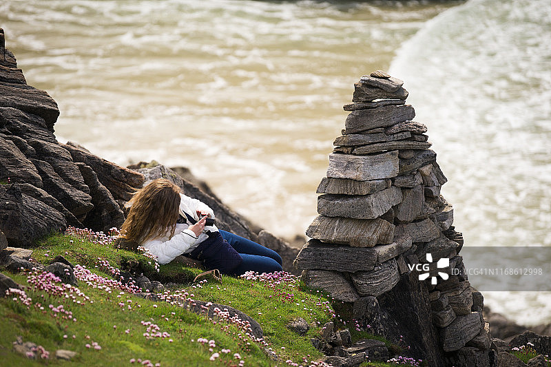 少女在苏格兰刘易斯岛拍摄粉色花朵图片素材