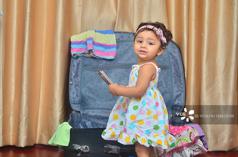 拿着手机准备旅行的3-7岁小女孩图片素材